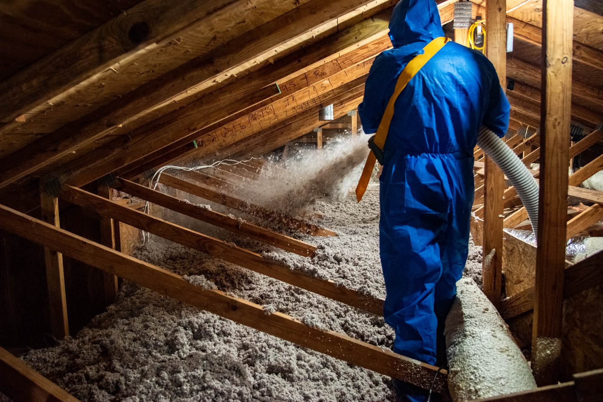 Restorative Home Solutions crew blowing insulation into a Fargo attic